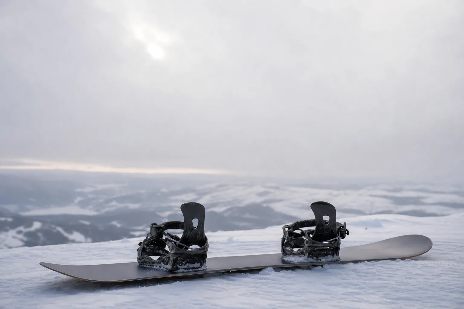 Snowboard sedd från sidan liggande på snö