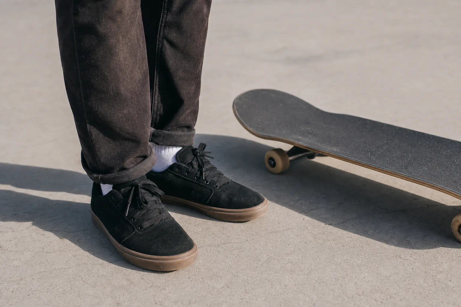 Skateskor med platt sula bredvid ett skateboarddeck