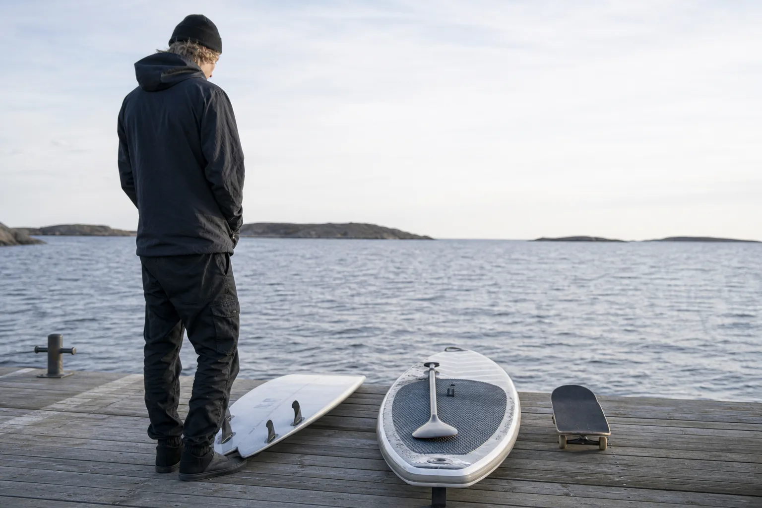 En person betraktar olika brädor upplagda bredvid varandra vid en brygga