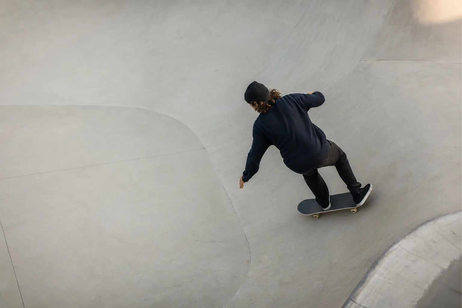Skateboardåkare i en mjuk sväng på en rundad betongyta