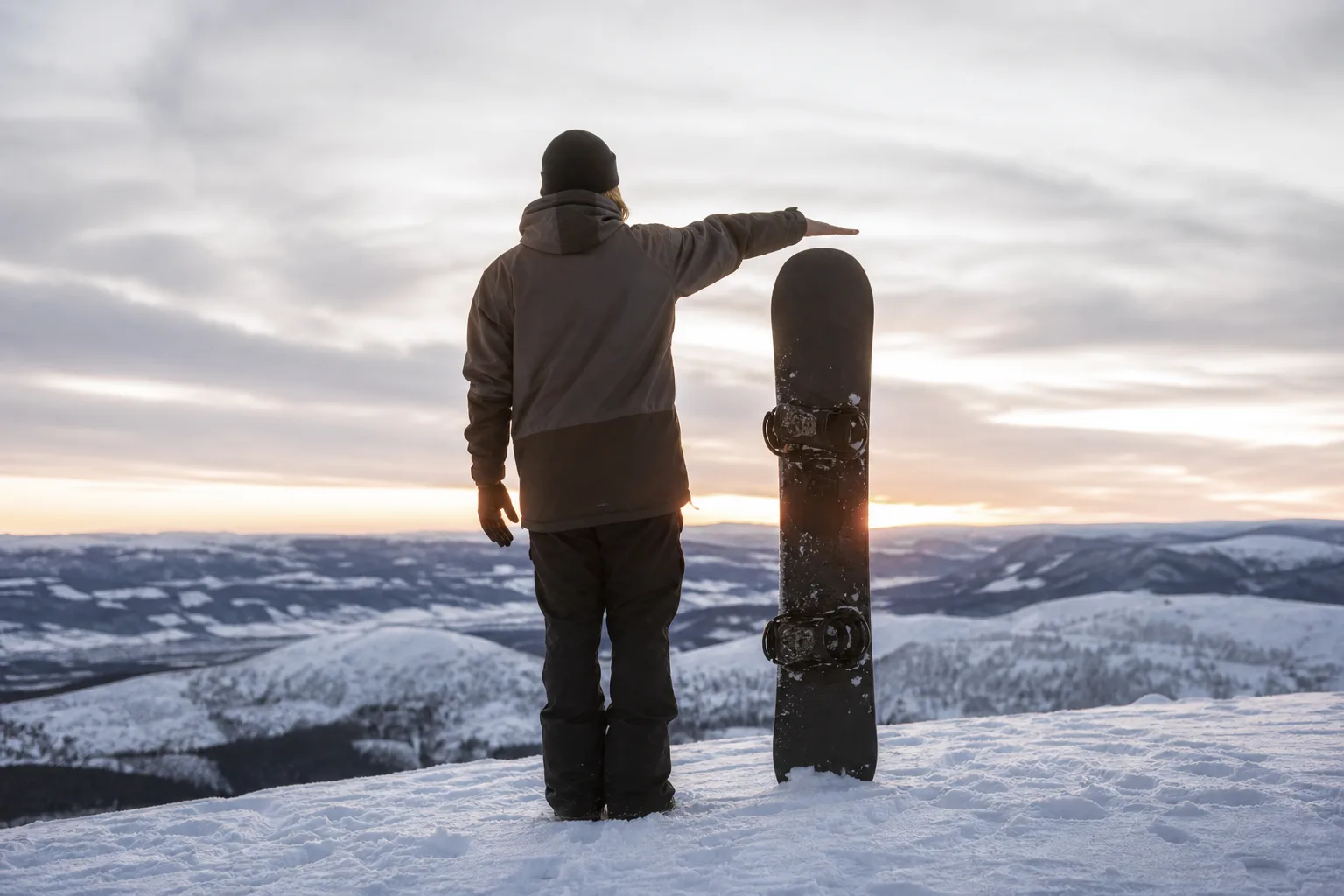 Snowboard ställd lodrätt i snön för att jämföra längd