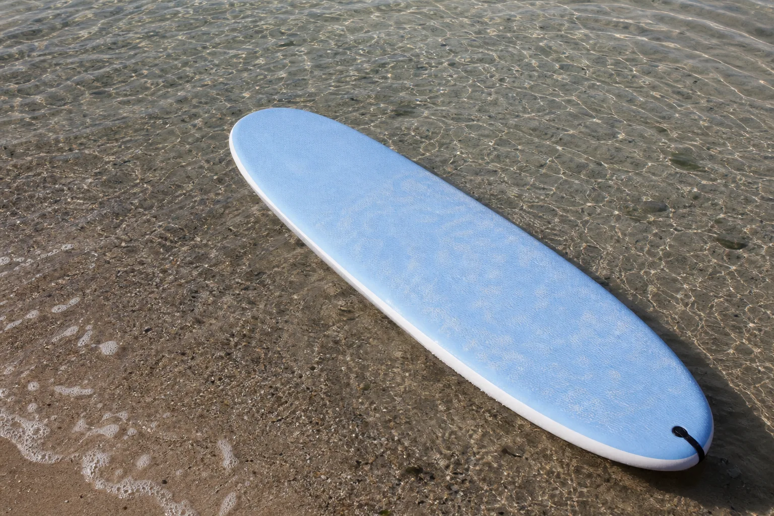Bred surfbräda med mjuk ovansida i grunt strandvatten