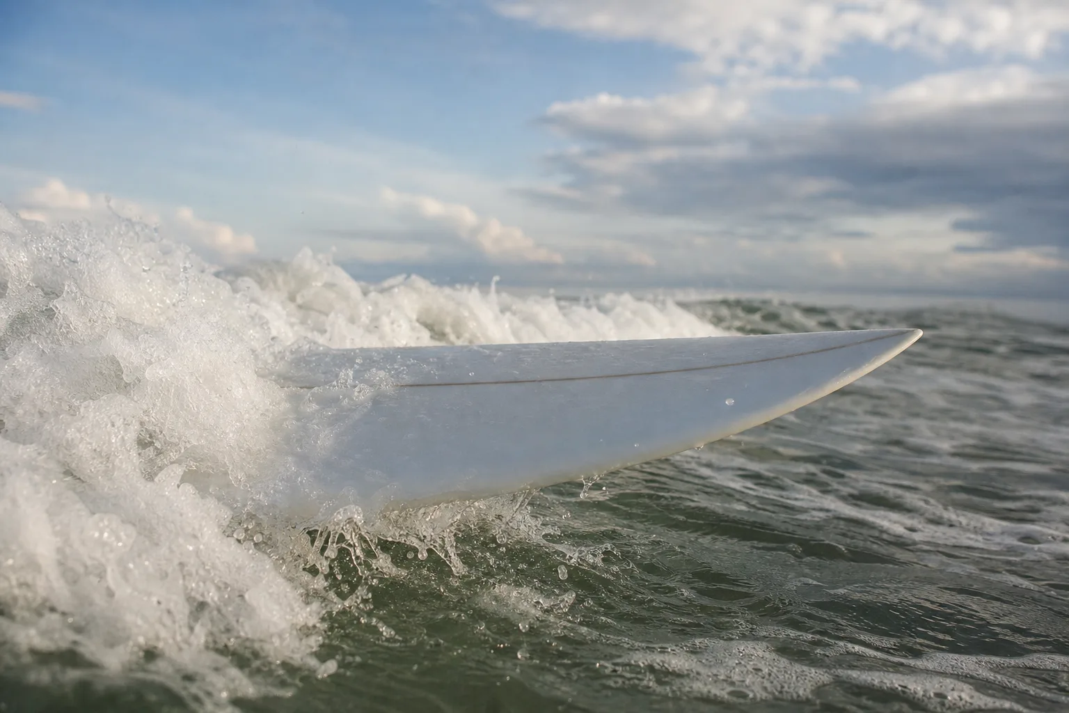 Surfbräda som glider genom skummande vitvatten sett från vattennivå