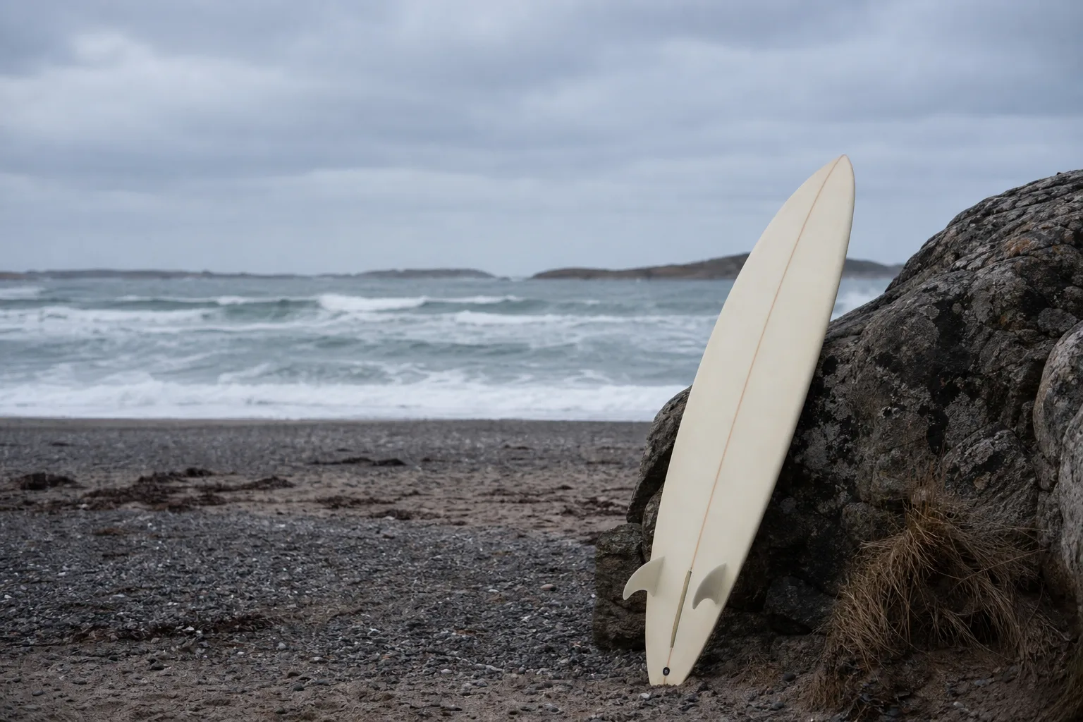 Surfbräda som lutar mot en klippa vid en blåsig västkuststrand